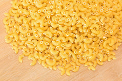 a-heap-of-uncooked-chifferi-rigati-pasta-on-wooden-kitchen-board-fat-and-unhealthy-food-classic-dry-macaroni-italian-culture-and-cuisine-raw-pasta-photo