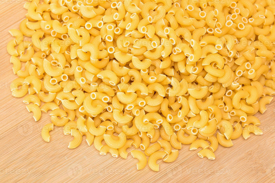 a-heap-of-uncooked-chifferi-rigati-pasta-on-wooden-kitchen-board-fat-and-unhealthy-food-classic-dry-macaroni-italian-culture-and-cuisine-raw-pasta-photo
