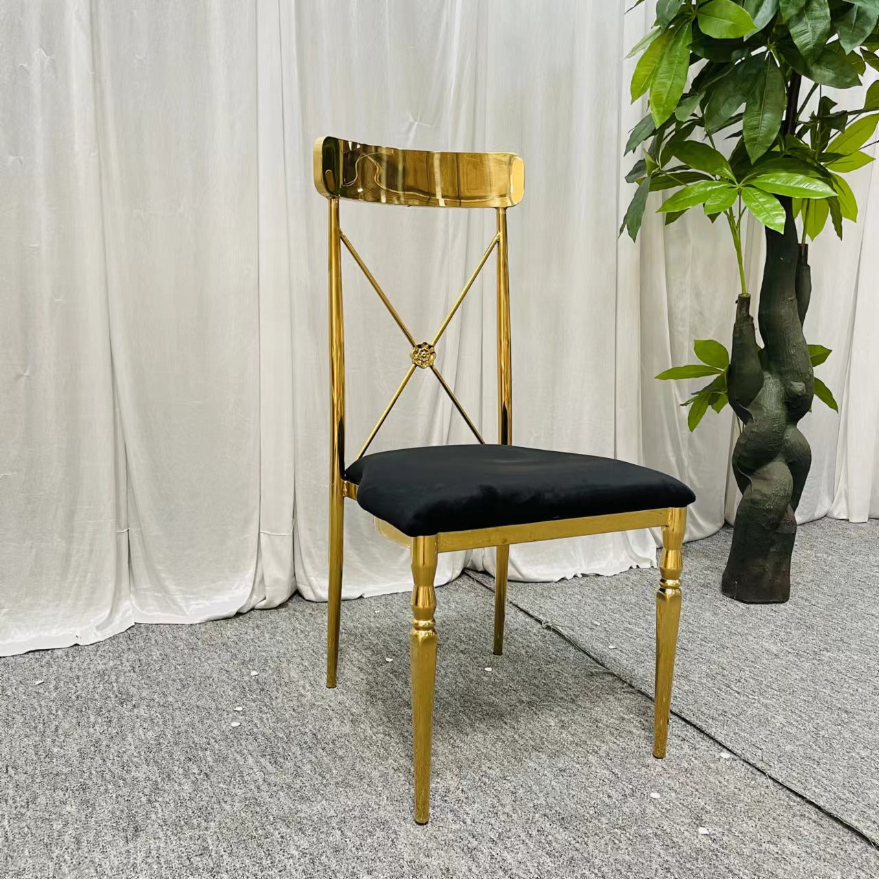 Golden Stainless steel chair with black velvet cushion.